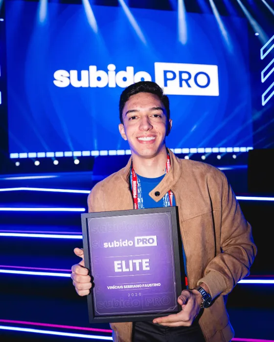Vinícius Sebriano no palco do Subido Pro segurando a placa da categoria Elite
